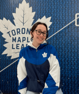 Alumni profile of Kaelin Williamson, featuring a competition photo of her on the uneven bars and a current portrait, alongside a testimonial about her lifelong connection to the All Star gym.