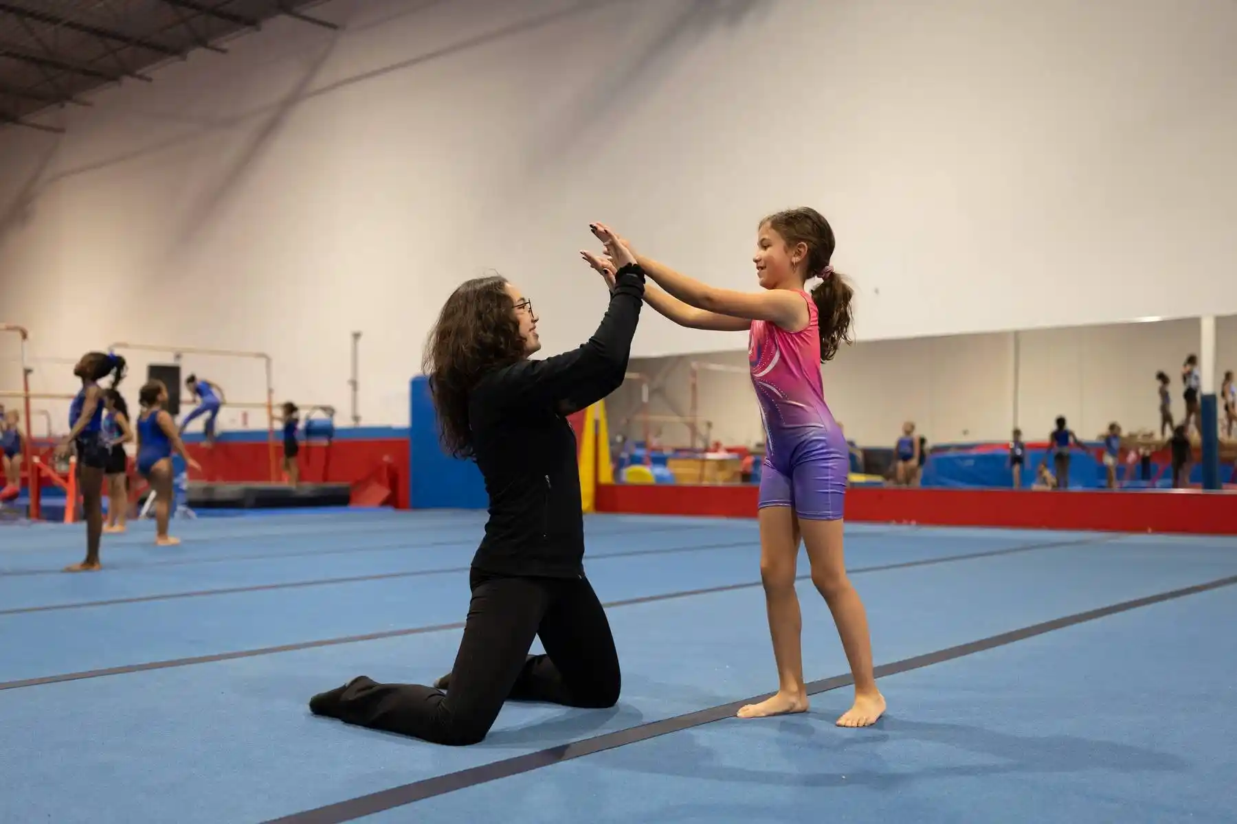 Silhouetted gymnasts in a gym with a blue overlay. Text lists reasons to choose All Star Sports Centre, including Experienced Team, Cleanliness, and Professionalism.